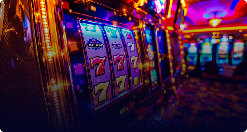 A row of brightly lit Multicasino slot machines with sevens and jackpots